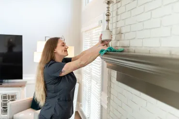 merry maid cleaning a fireplace mantle